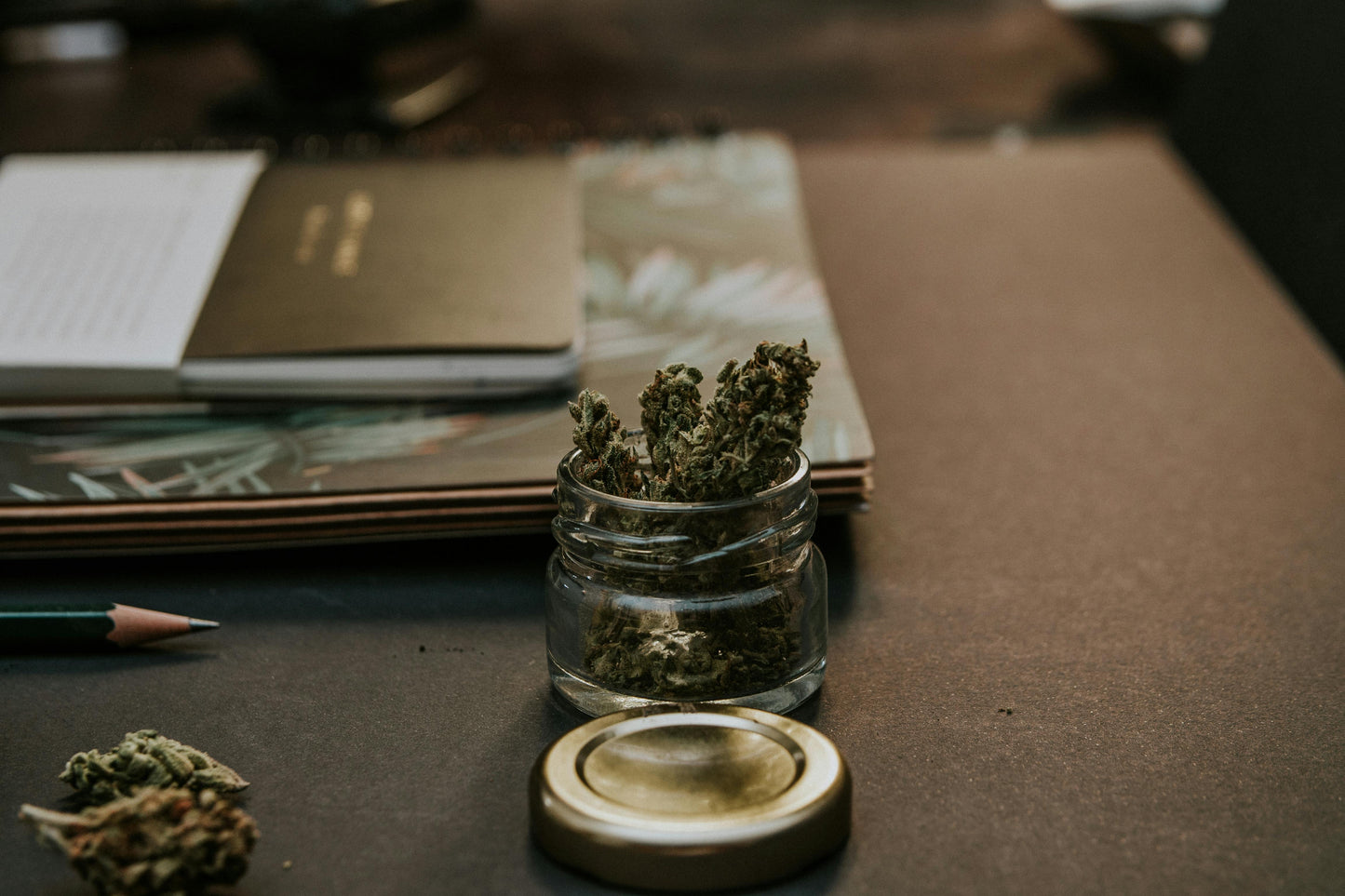 flor cannabis cbd en una mesa dentro un bote de cristal abierto 